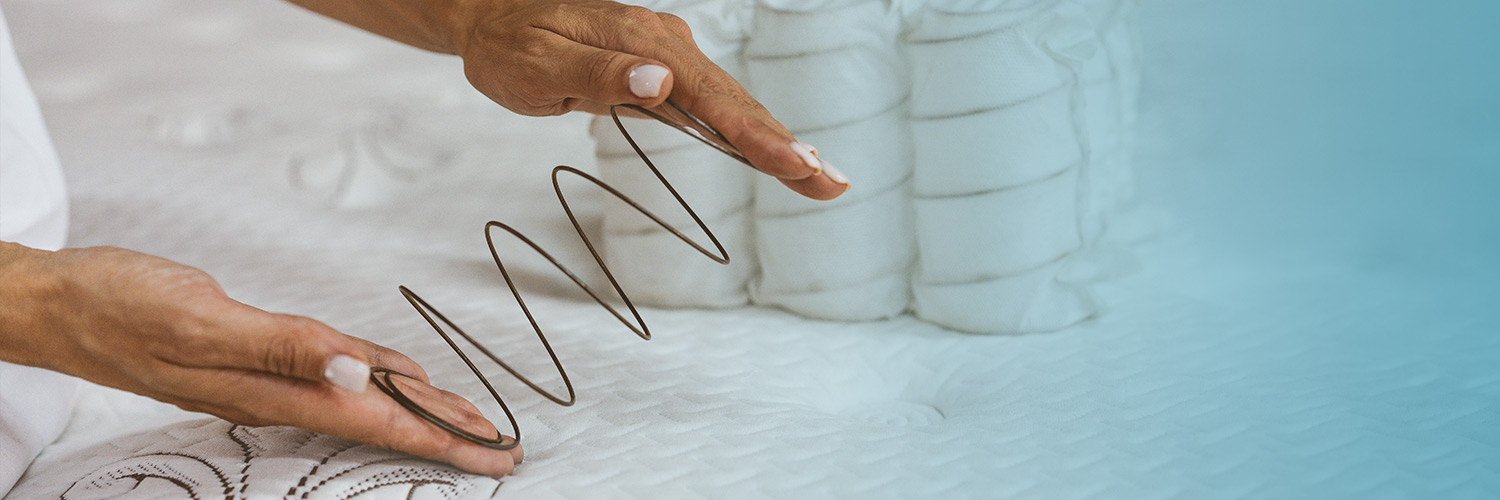 a woman examining the strength of a mattress spring